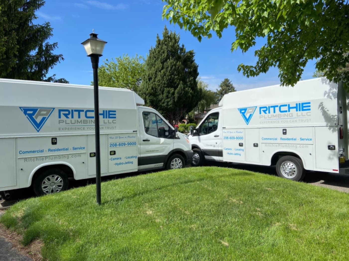 Ritchie Plumbing vans on a residential street during service work in the Treasure Valley, including Kuna